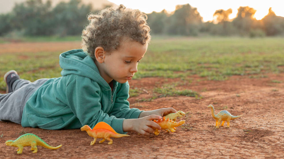 bambino che gioca con dei dinosauri