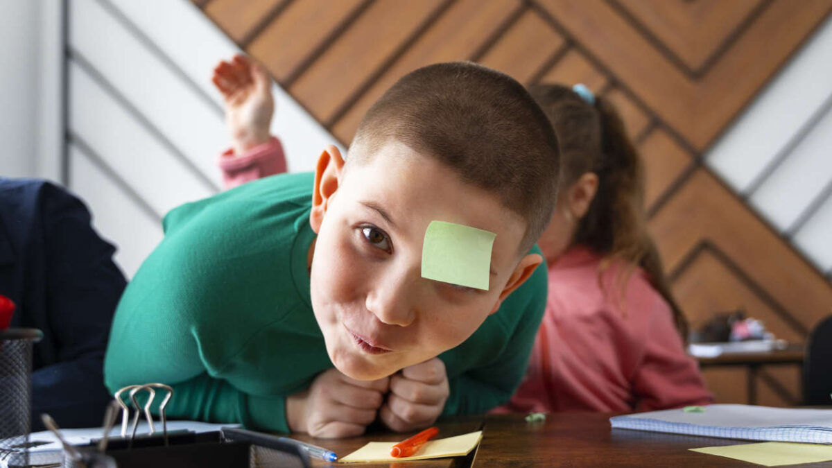 bambino semi disteso su di un bamco con attaccato in fronte un post-it