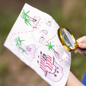 bambino che guarda una mappa con una lente di ingrandimento