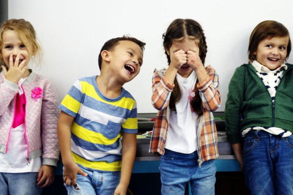 quattro bambini sorridenti davanti ad una lavagna