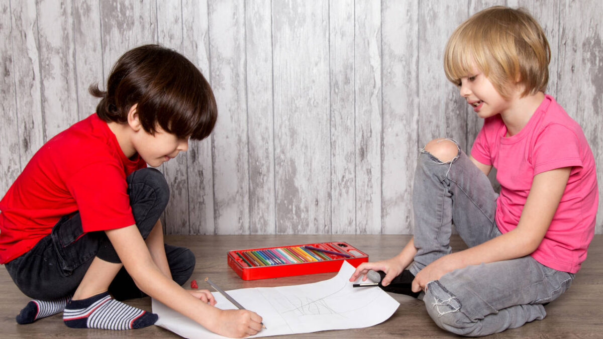 due bambini inginocchio che scrivono su di un pezzo di carta